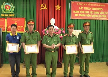 Đồng chí Đại tá Lâm Phước Nguyên, Phó Giám đốc Công an tỉnh (đứng giữa) trao Giấy khen cho tập thể, cá nhân có thành tích xuất sắc