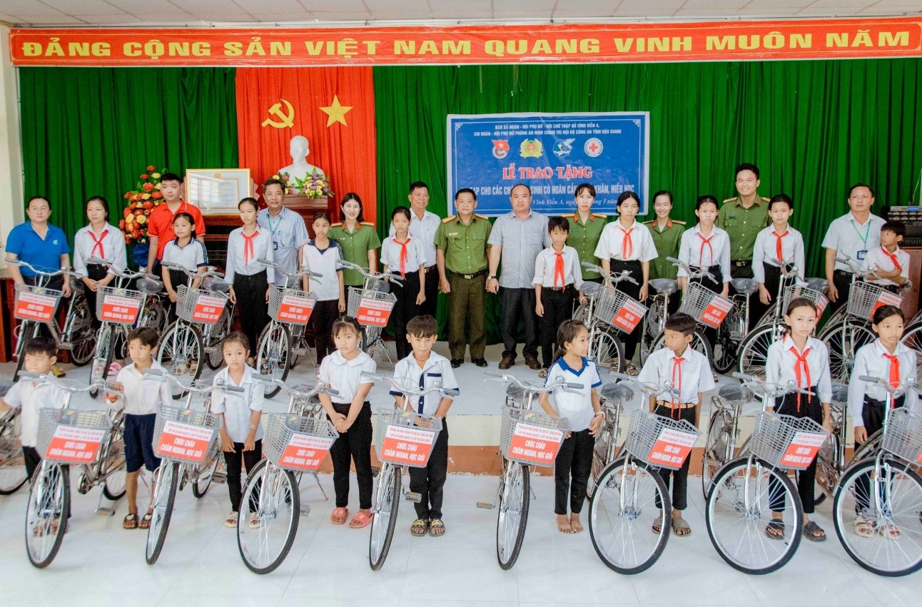 Đồng chí Đại tá Nguyễn Hoàng Lợi, Bí thư Chi bộ, Trưởng phòng An ninh chính trị nội bộ trao xe đạp cho các cháu học sinh