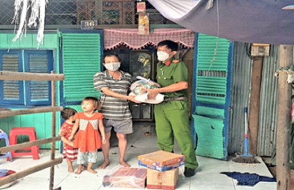 Đồng chí Thiếu tá Nguyễn Hoàng Duy, Trưởng Công an thị trấn Cái Tắc trao quà cho hộ dân có hoàn cảnh khó khăn trên địa bàn